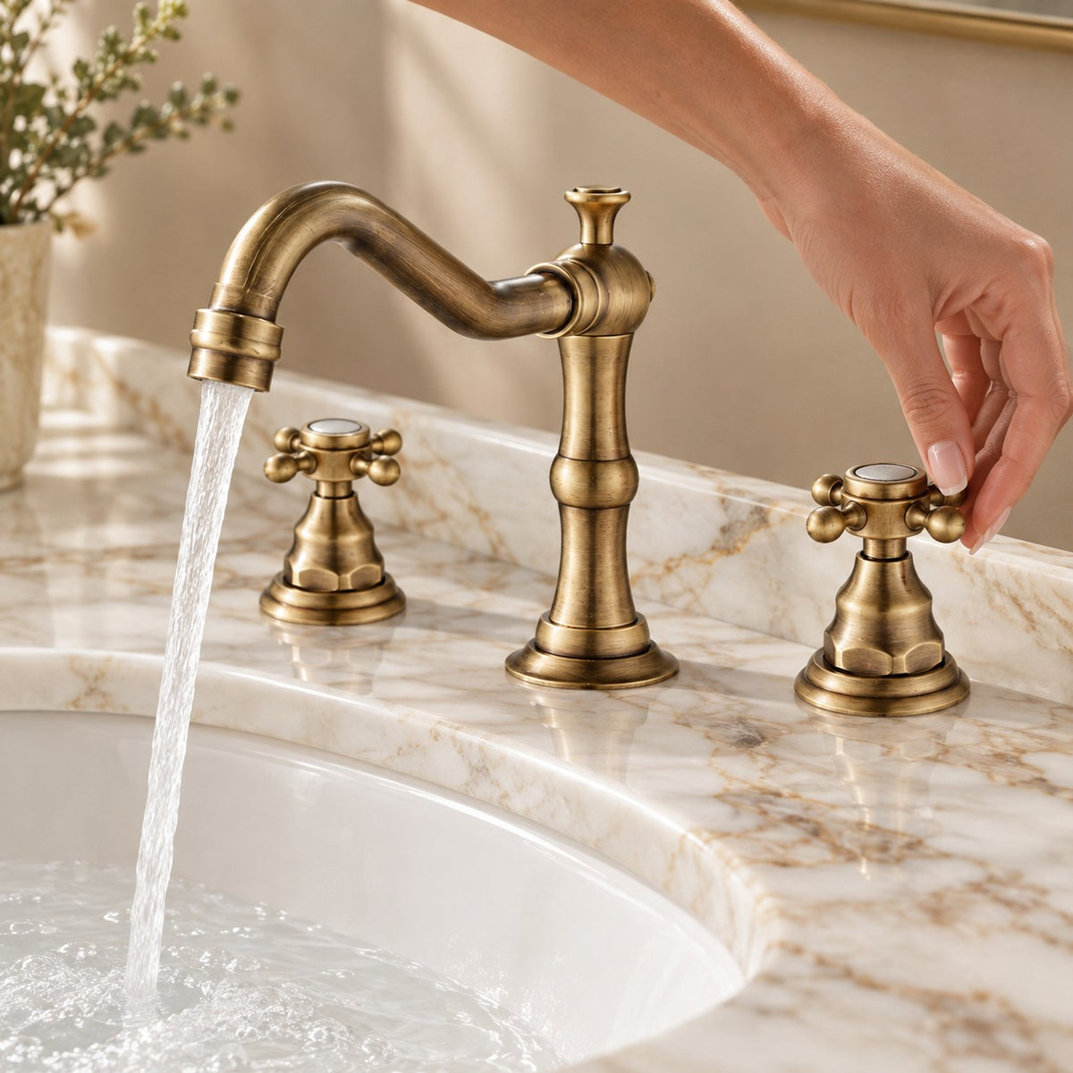 Mélangeur lavabo 3 trous ALVERIO avec une main sur la commande, plan en marbre, mise en situation