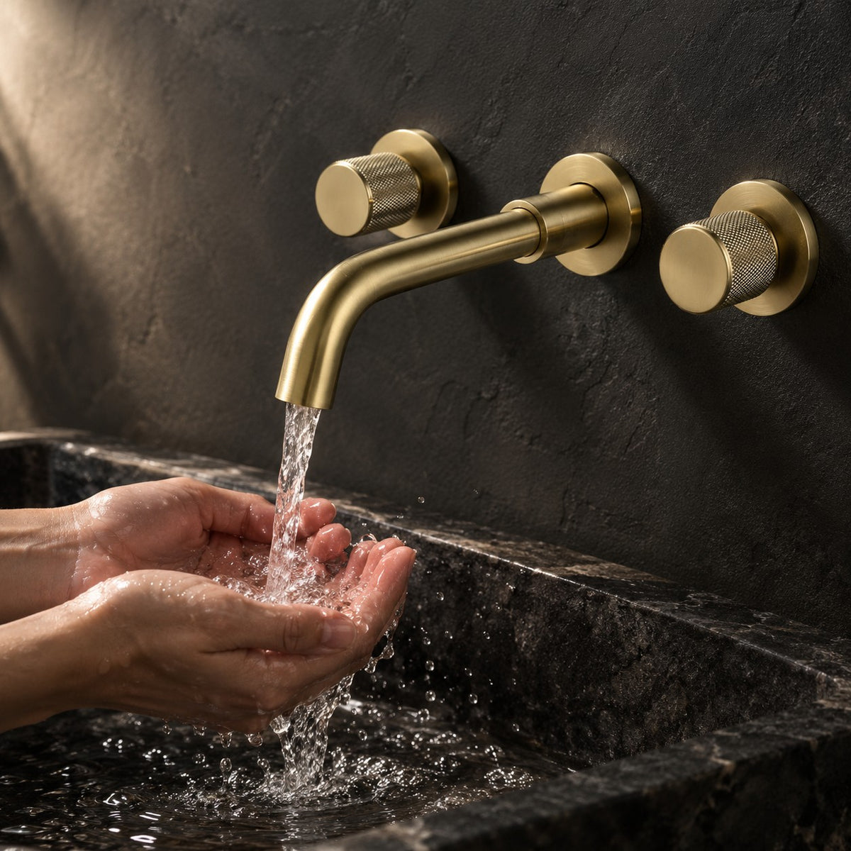 Mélangeur lavabo mural BELLAVIO mains sous le jet, mur anthracite, mise en situation