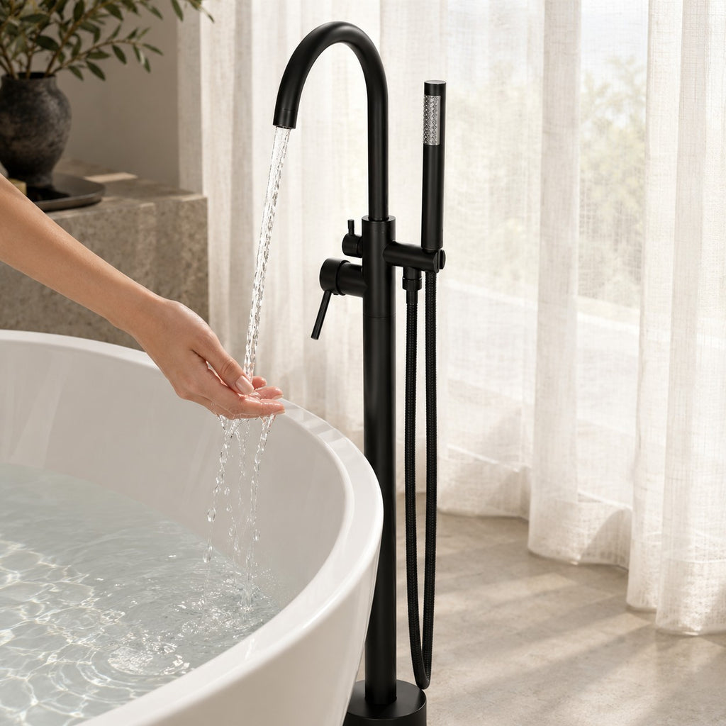 Mitigeur baignoire sur pied avec douchette VARELLO avec une main sous le jet, baignoire îlot, mise en situation