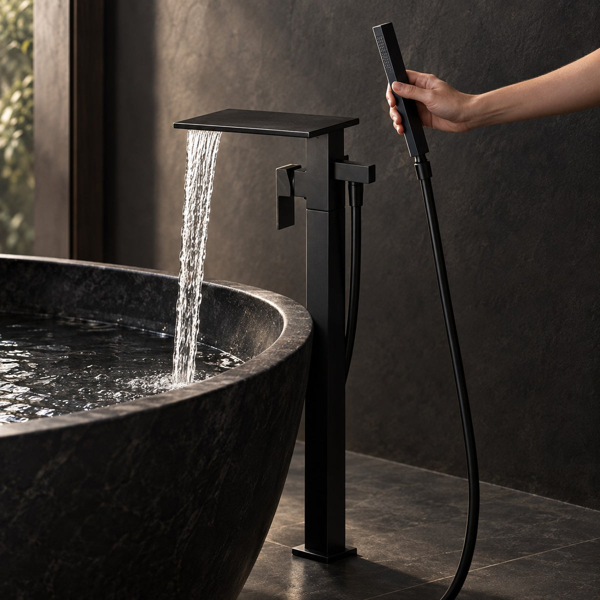Mitigeur baignoire sur pied cascade MONZARIO avec une main, baignoire en pierre noire, mise en situation