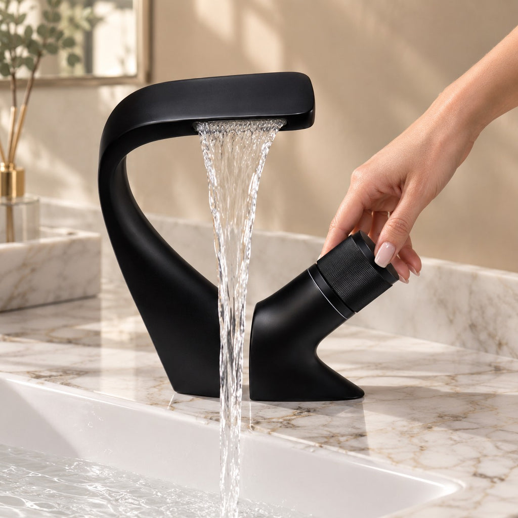 Mitigeur lavabo cascade design CIGNARO avec une main sur la commande, plan en marbre, mise en situation