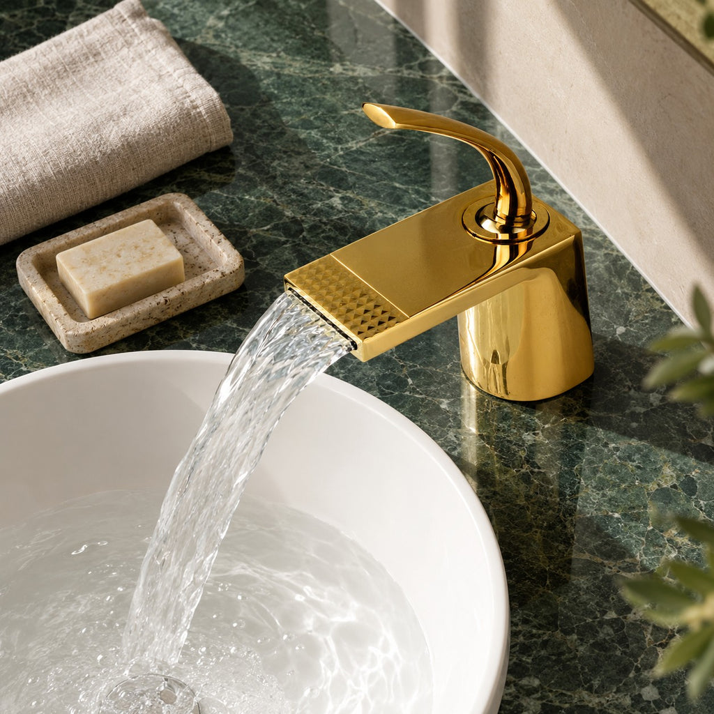 Mitigeur lavabo cascade doré AURELIO vue plongeante sur un plan en marbre vert, mise en situation