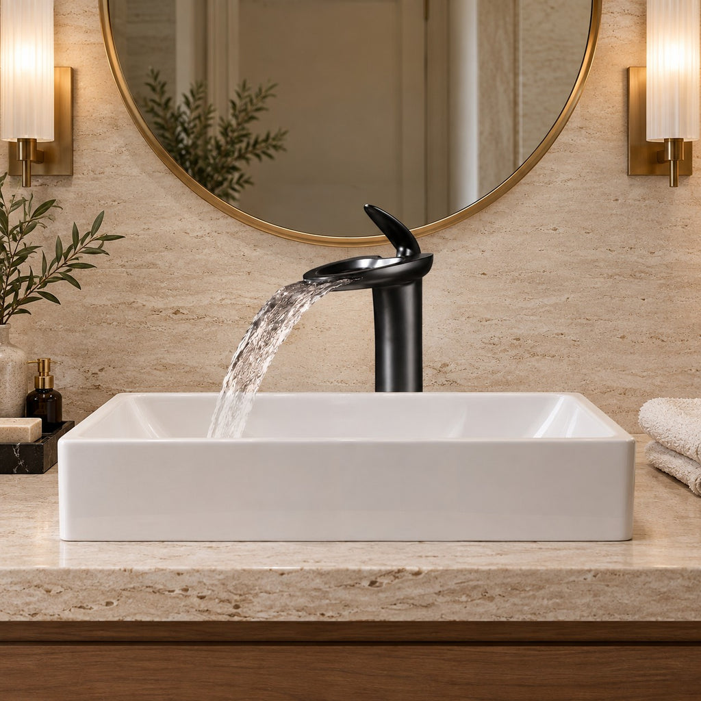 Mitigeur lavabo cascade NOVELLI vu de face sous un miroir rond, plan en travertin, mise en situation