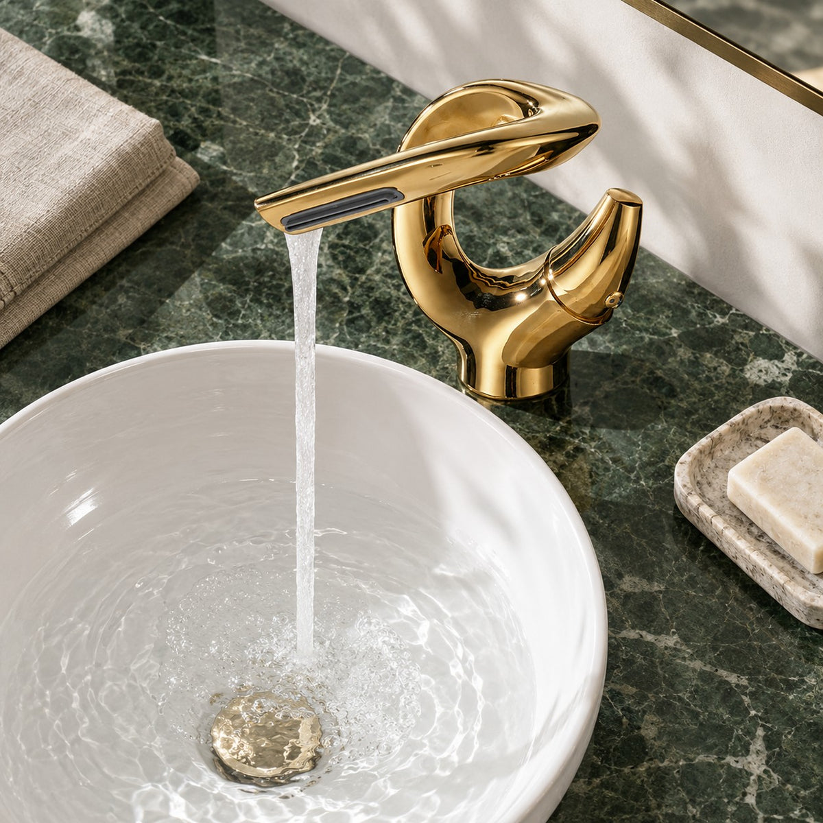 Mitigeur lavabo cascade sculptural OREZIO vue plongeante sur un plan en marbre vert, mise en situation