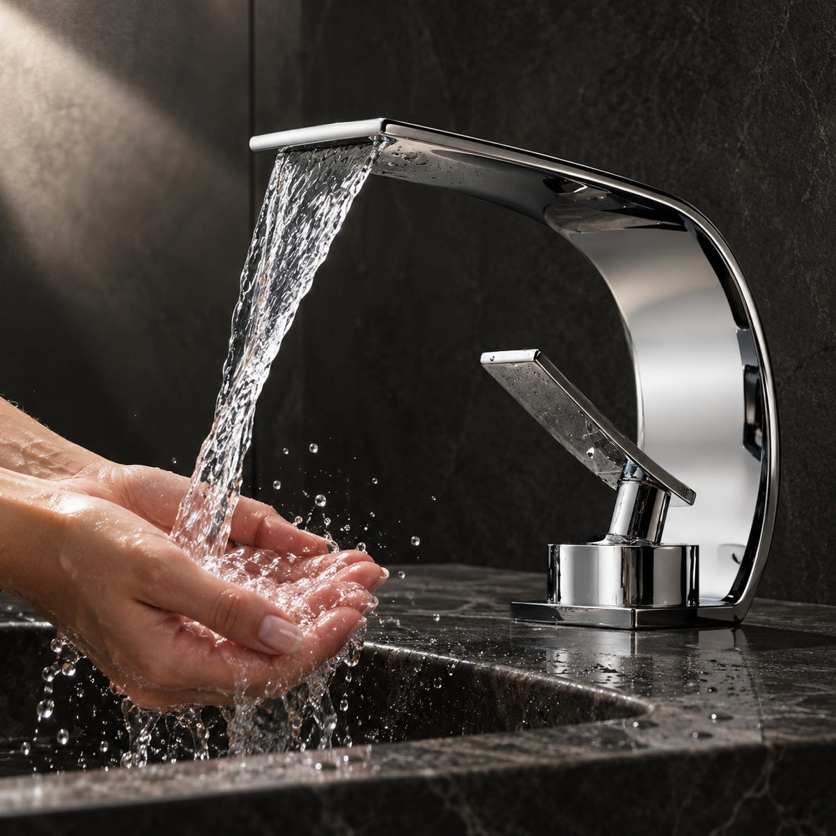 Mitigeur lavabo cascade VALTERO mains sous le jet, vasque en pierre noire, mise en situation