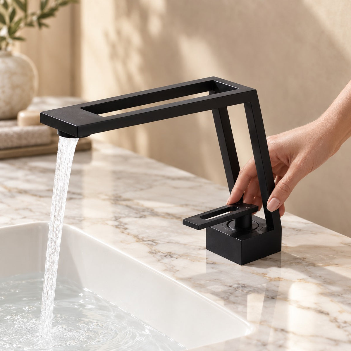 Mitigeur lavabo design ARCHENZO avec une main sur la commande, plan en marbre, mise en situation