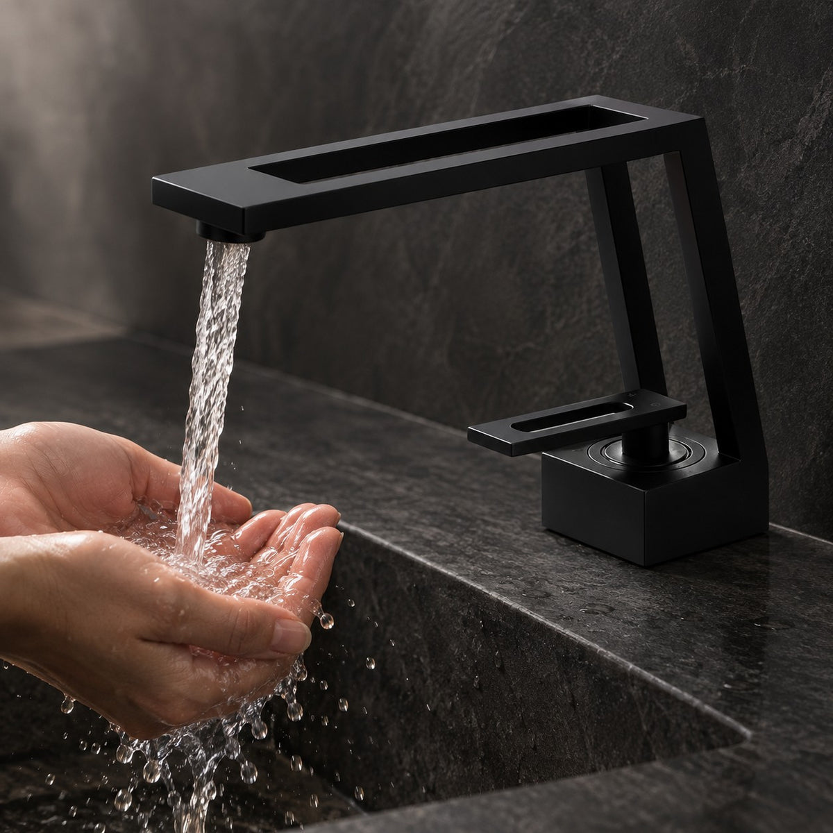 Mitigeur lavabo design ARCHENZO mains sous le jet, vasque en pierre noire, mise en situation