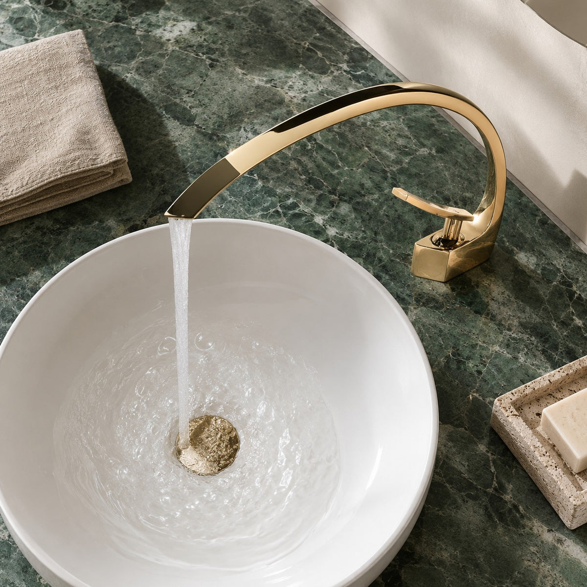 Mitigeur lavabo design courbé LUNAVIO doré vue plongeante sur un plan en marbre vert, mise en situation