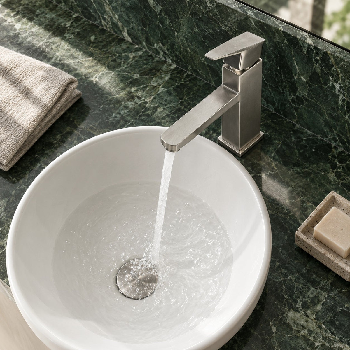 Mitigeur lavabo minimaliste VARESSI vue plongeante sur un plan en marbre vert, mise en situation