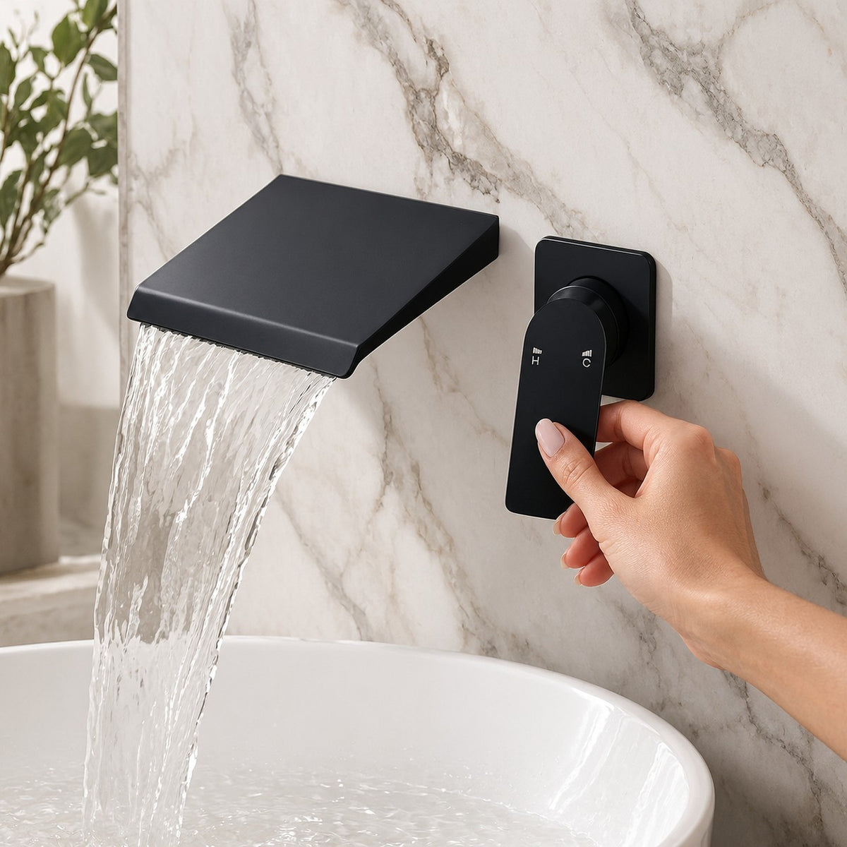 Mitigeur lavabo mural cascade ROTEVIO avec une main sur la commande, mur en marbre, mise en situation