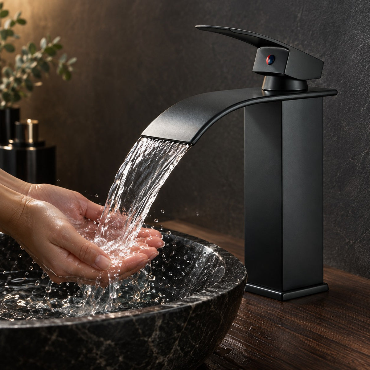 Mitigeur vasque haut cascade SEREVIO mains sous le jet, vasque en pierre noire, mise en situation