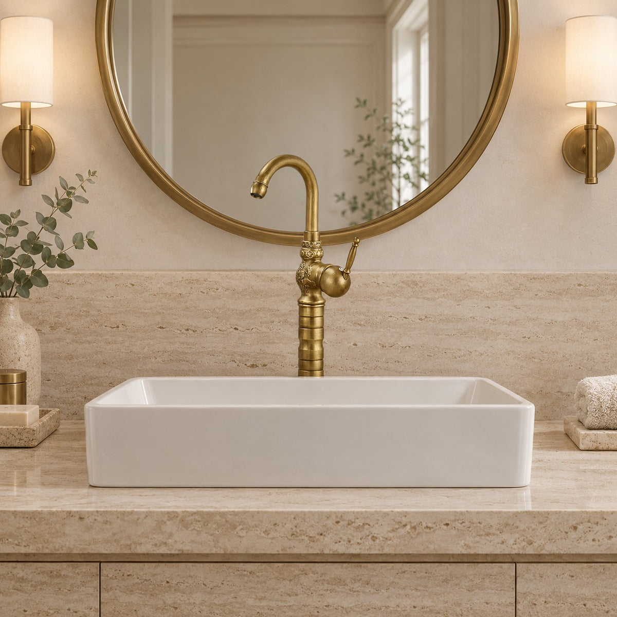Robinet lavabo rétro en laiton FLORENZO vu de face sous un miroir rond, plan en travertin, mise en situation